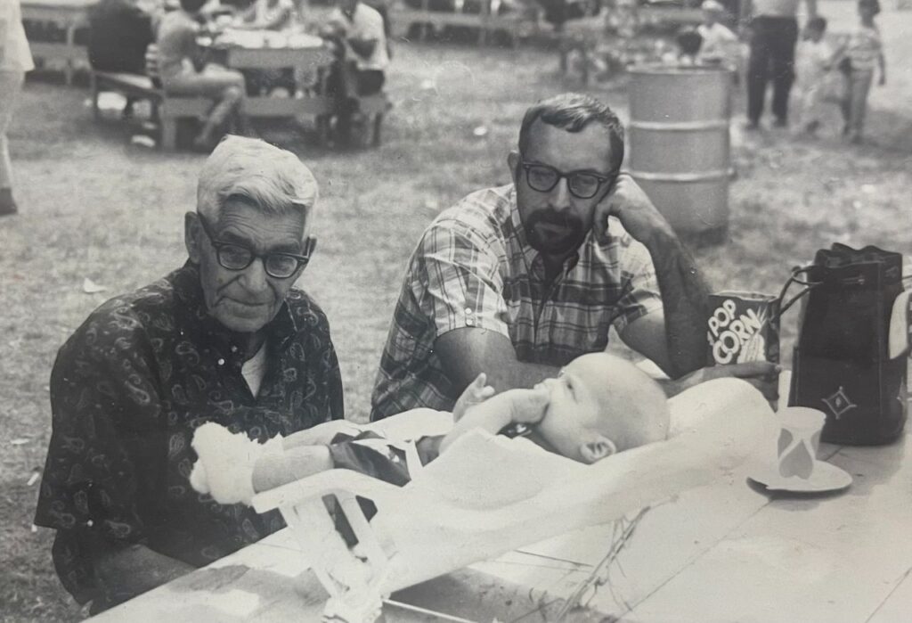 Joe's maternal grandfather Jesse Bowman, Joseph Bruchac, and his grandson James sharing family stories at a picnic.